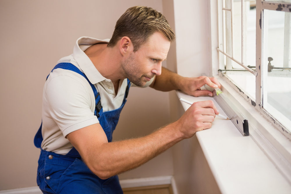 Man using spirit level to install new windows